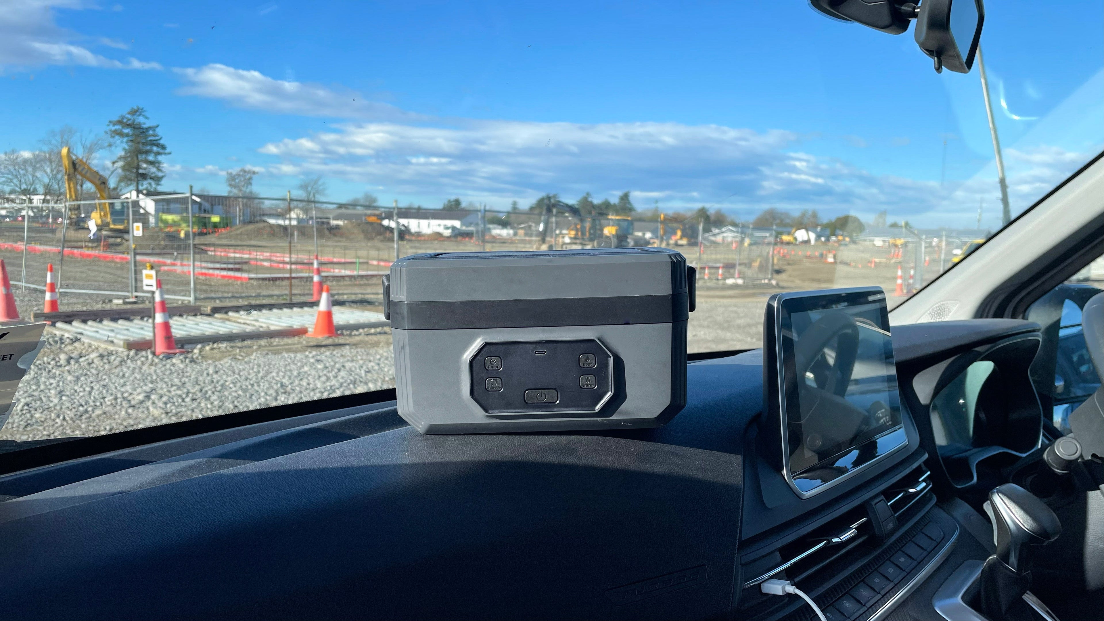 Norva Wireless Heated Lunchbox on the dashboard of a van in a construction site. 